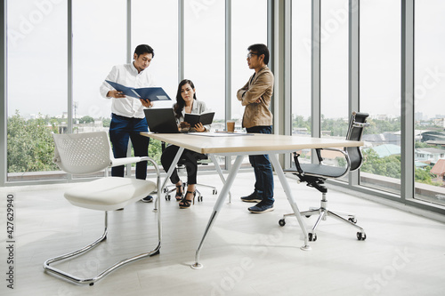 Manager and secretary check information discussing with managing director in meeting room; Business meeting concept