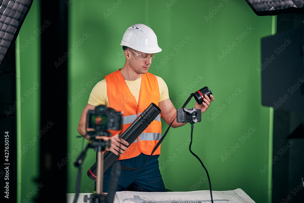 Handsome male builder recording video for construction blog