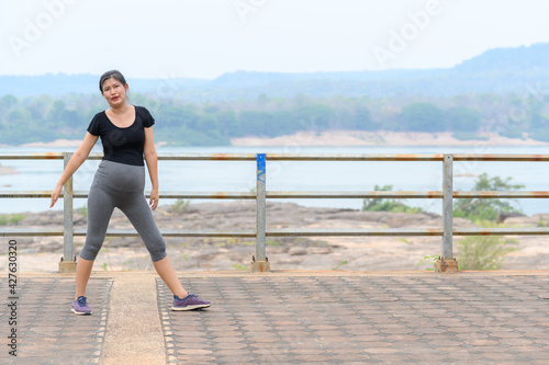 healthy pregnant woman doing yoga in nature outdoors. Prenatal yoga is a way to maintain a healthy mind and body to increase strength and flexibility.