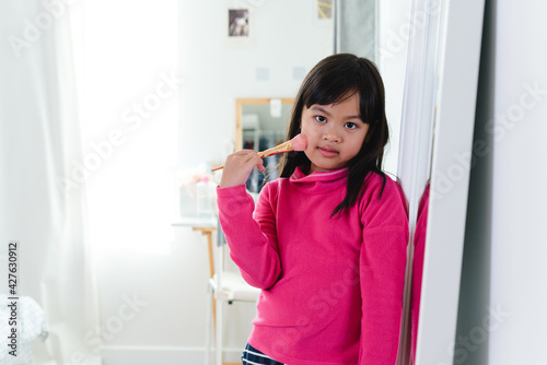 Asian Child make up beautiful little girl in the mirror preening. little beauty