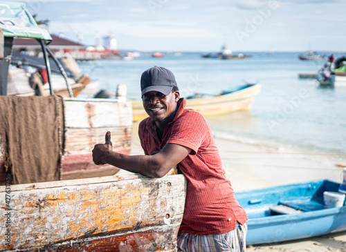 Candid black fisherman on coast ocean photo