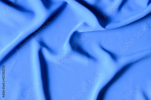 The background is made of a delicate blue chiffon fabric with folds in the form of waves.