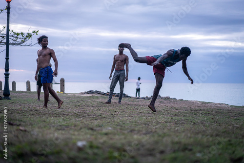 Young men exercising martial arts on the beach