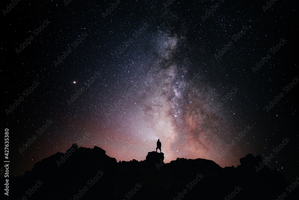 silueta una persona de pie mirando el campo de estrellas y la vía lactea
