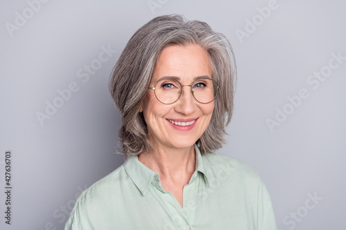 Photo of happy smiling cheerful beautiful mature smart businesswoman in glasses isolated on grey color background