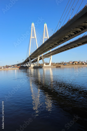 View of the cable-stayed bridge pylons and a fragment of the highway with reflexes in the water  for a thematic banner