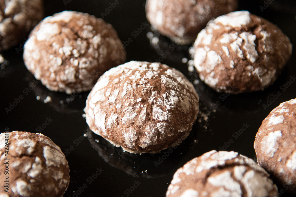 Cracked chocolate cookies with icing sugar on a pan Cracked chocolate cookies with icing sugar on a pan