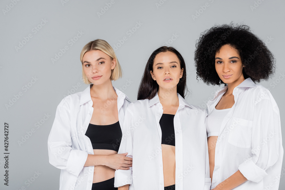pretty multiethnic women in white shirts and underwear posing isolated on grey pretty multiethnic women in white shirts and underwear posing isolated on grey