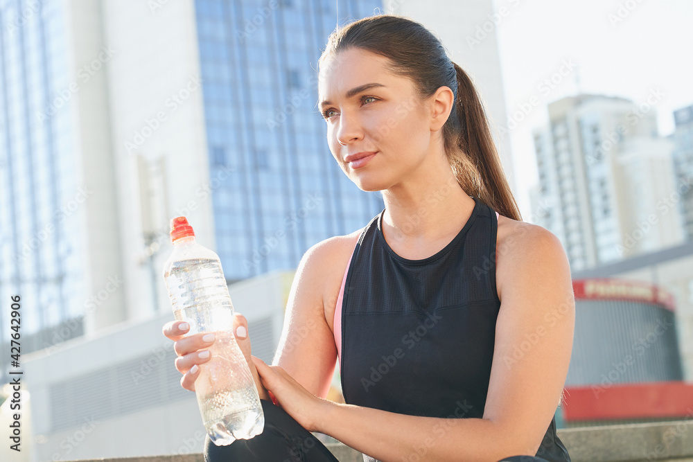 Attractive young sports girl with a bottle of water in hand. Attractive young sports girl with a bottle of water in hand.