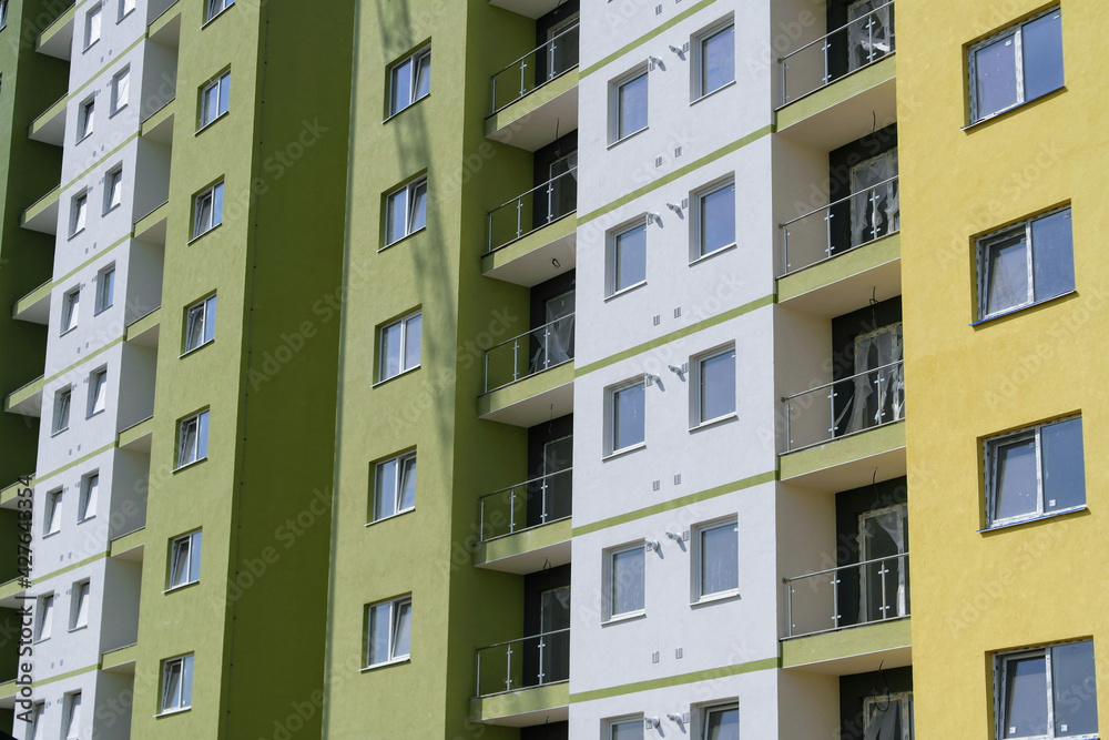 Colorful facade of a modern high-rise apartment building with balconies and lodges