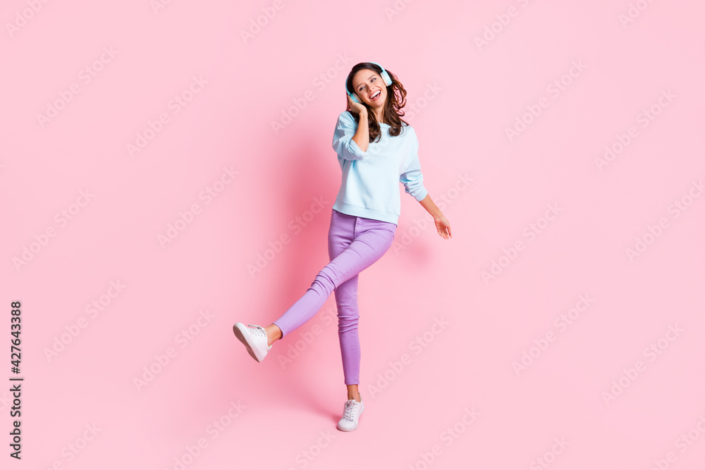Full length photo of young attractive girl happy positive smile enjoy music earphones isolated over pink color background