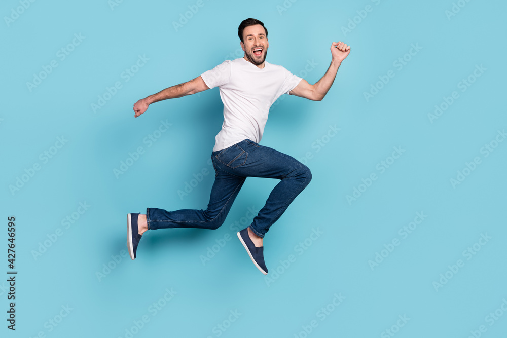 Full length profile photo of satisfied person running toothy smile look camera isolated on blue color background Full length profile photo of satisfied person running toothy smile look camera isolated on blue color background