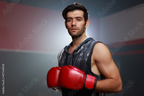 Portrait young fit strong Caucasian man wearing boxing gloves standing getting ready to do boxing, healthey recreation lifestyle.