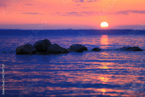 stones in lake water on sunset