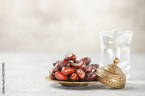 Photography A glass of water and dry dates on saucer ready to eat for iftar time