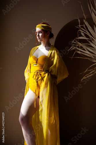 Beautiful fashion red head woman in yellow summer dress