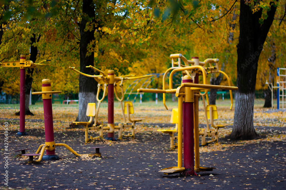 Fototapeta premium Workout fitness facility playground with metal sports equipment outdoors on a nice autumn or fall day