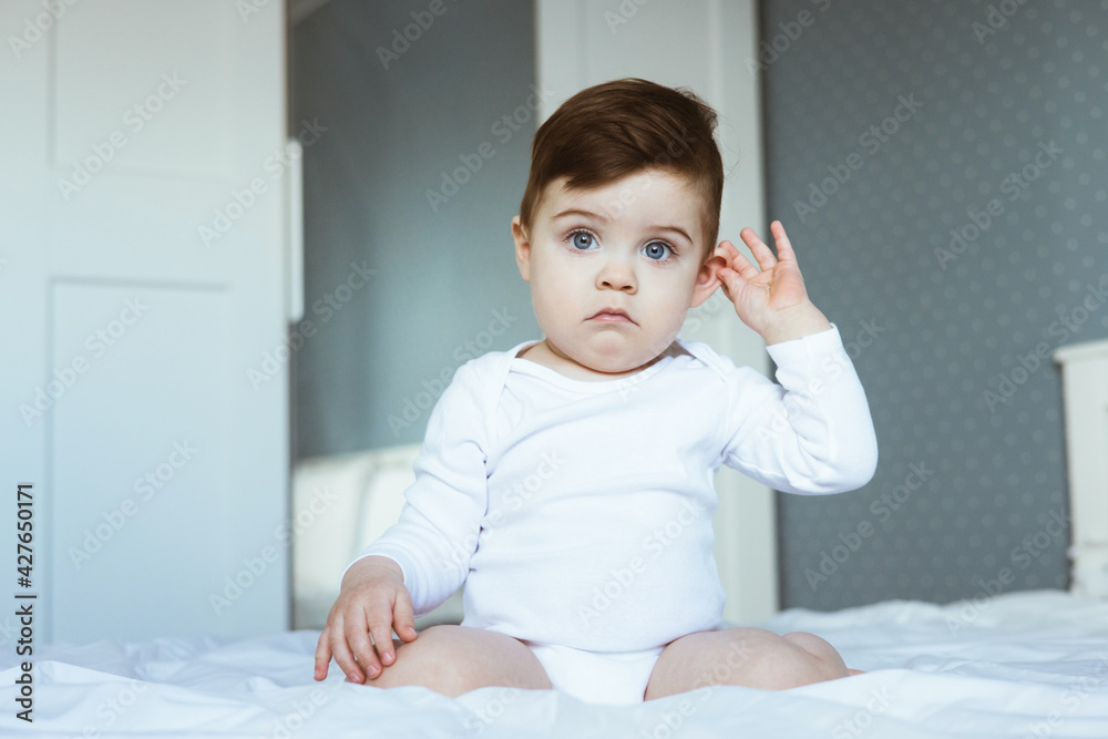 Fototapeta premium Little boy with ear pain moaning holding hand on ear at home, child headache pain, health care concept, ear protection , teeth pain