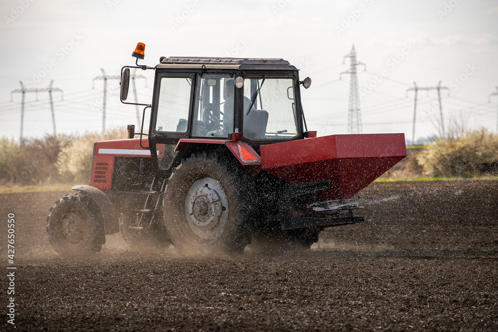 Fototapeta premium Tractor spreading artificial fertilizers