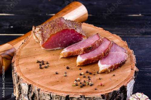 Dried pork, polendwitz, jerky tenderloin on wooden background. Cured pork meat. Polenitsa is a dry-cured filet. Dish of Belarusian cuisine photo