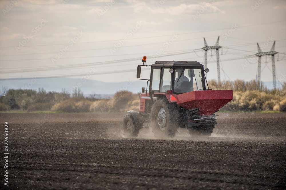 Fototapeta premium Tractor spreading artificial fertilizers