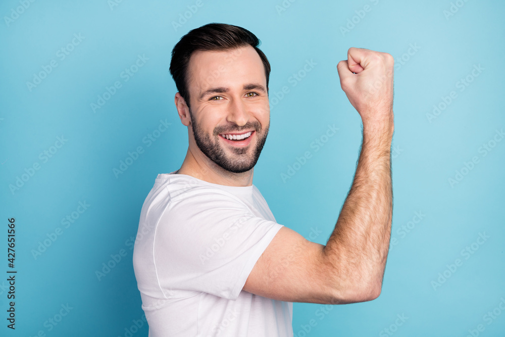 Profile side view portrait of attractive cheerful guy celebrating success isolated over blue bright pastel color background Profile side view portrait of attractive cheerful guy celebrating success isolated over blue bright pastel color background