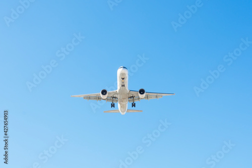 Jet plane flying in blue sky, approach for landing.