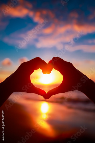 heart with hands, sunset background, love and travel