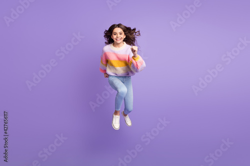 Full size photo of young happy cheerful smiling little girl running fast speed in air isolated on violet color background
