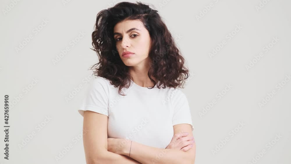 The proud woman with holding the crossing arms in front of her while standing in the studio The proud woman with holding the crossing arms in front of her while standing in the studio