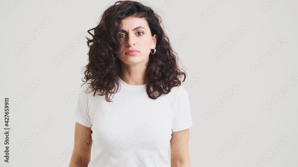 The angry woman clenching hands in fists and jumping in the place in the studio The angry woman clenching hands in fists and jumping in the place in the studio