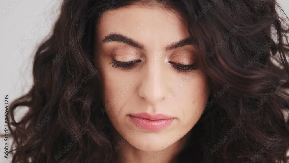 The close-up view of a woman's face looking at the camera with a smile The close-up view of a woman's face looking at the camera with a smile