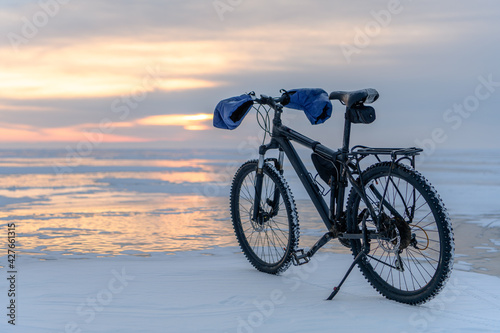 Bycicle on Baikal lake in winter on the sunrise. Irkutsk Region, Russia