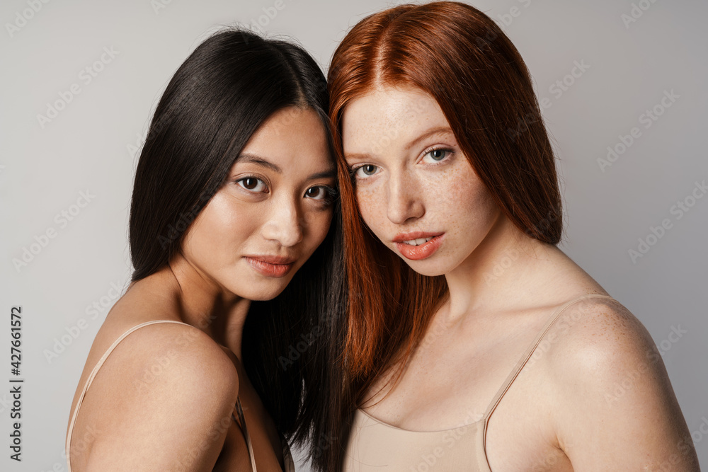 Multiracial two women posing and looking at camera Multiracial two women posing and looking at camera