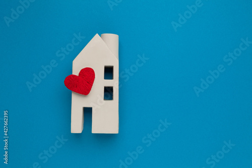 Orphanage and adoption concept. Toy house with a heart on a blue background. Real estate insurance.