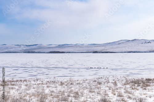 Ogoy island winter landscape. View of the mountains and frozen Lake Baikal on a winter day