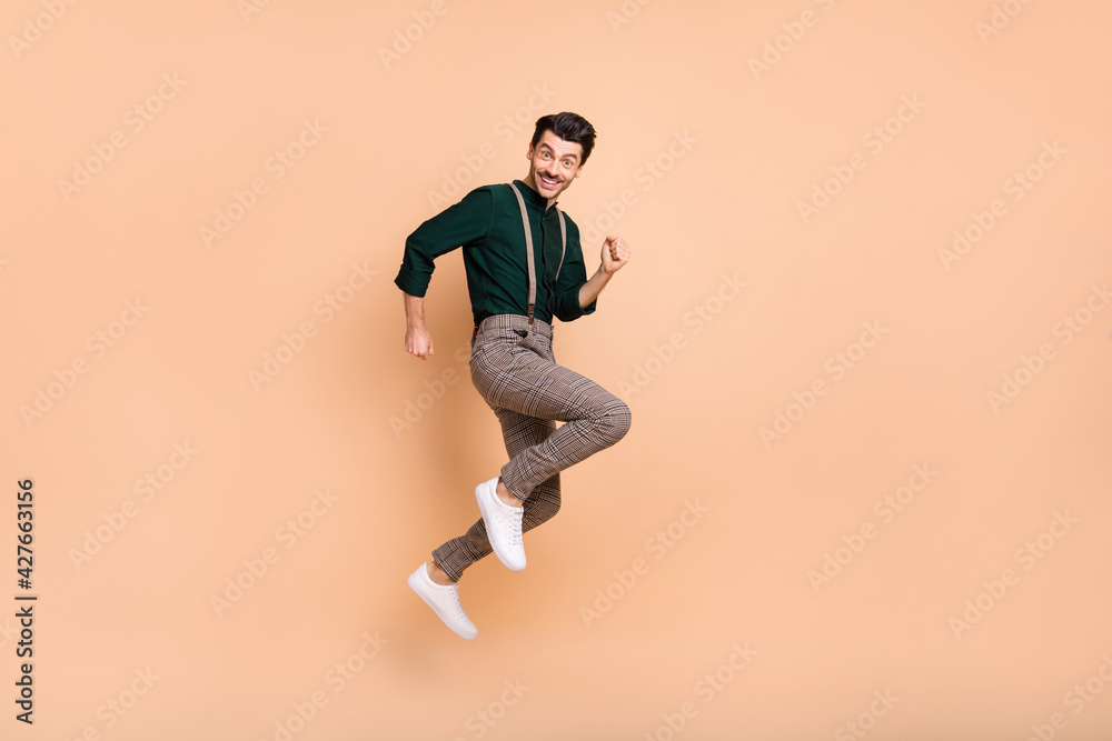 Full size profile side photo of charming funky man jump up air runner empty space sale isolated on beige color background