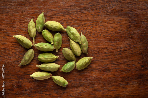 Macro close-up of Organic Cardamom or cardamum  Elettaria cardamomum  on wooden top background. Pile of Indian Aromatic Spice. Top view