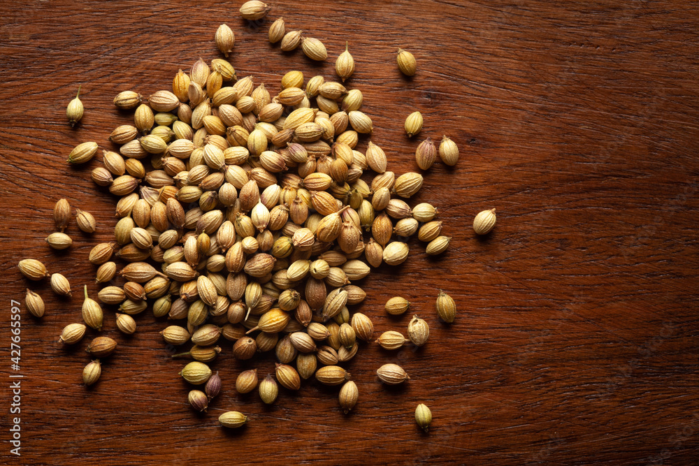 Macro close-up of Organic Coriander( Coriandrum sativum ) on wooden top background. Pile of Indian Aromatic Spice. Top view Macro close-up of Organic Coriander( Coriandrum sativum ) on wooden top background. Pile of Indian Aromatic Spice. Top view