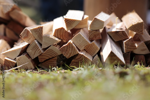 Stack of firewood on the grass at the park. Stack of kindling on the grass in the garden.