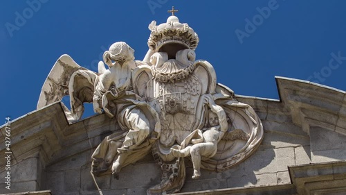 Sculpture on the top of The Puerta de Alcala timelapse hyperlapse (Alcala Gate) with flowers and traffic is a Neo-classical monument in the Plaza de la Independencia (Independence Square) in Madrid