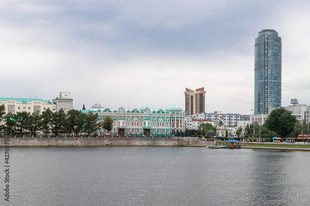 Embankment of city with buildings of Ural State University of Architecture and high tower of business center Vysotsky. Russia, Yekaterinburg, 10.07.2019