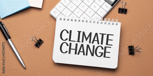 climate change on notepad with pen, glasses and calculator