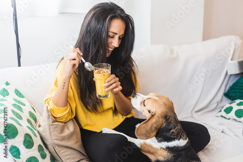 beautiful young woman drink a smoothie with her dog