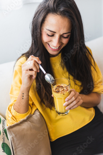 Young beautiful woman eating a healthy smoothie