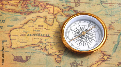 Classic round compass on background of old vintage map of world as symbol of tourism with compass  travel with compass and outdoor activities with compass