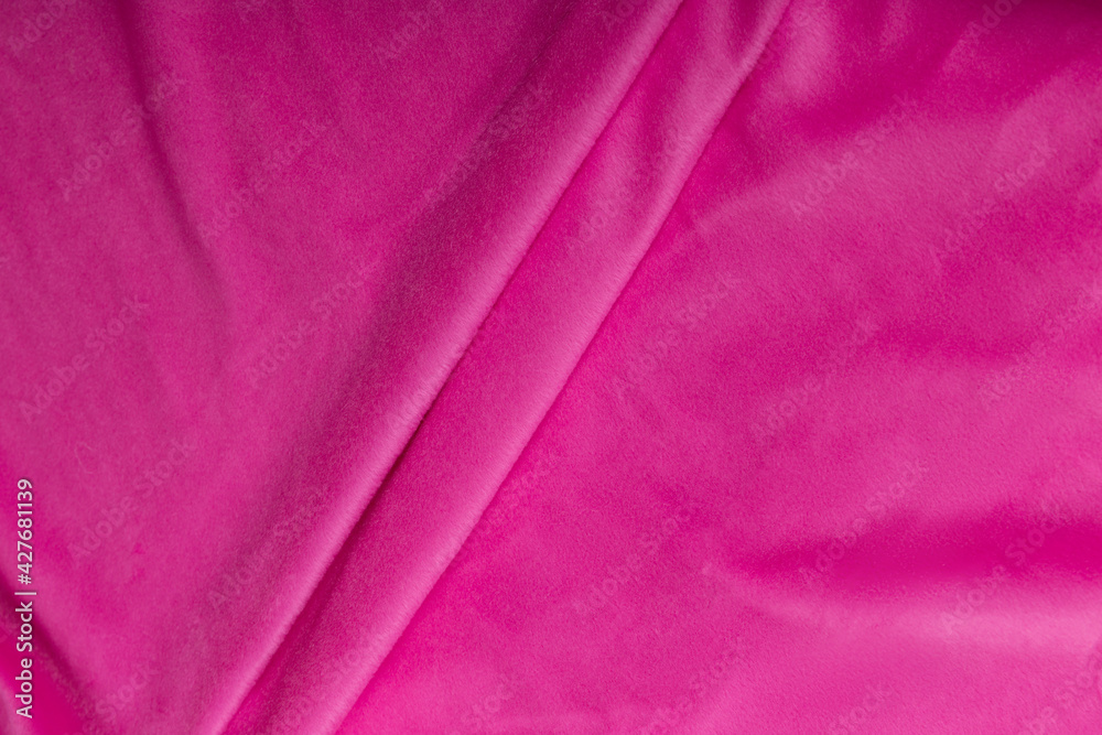 Obraz premium Colored rose textile satin fabric folded in folds and waves with highlights and texture