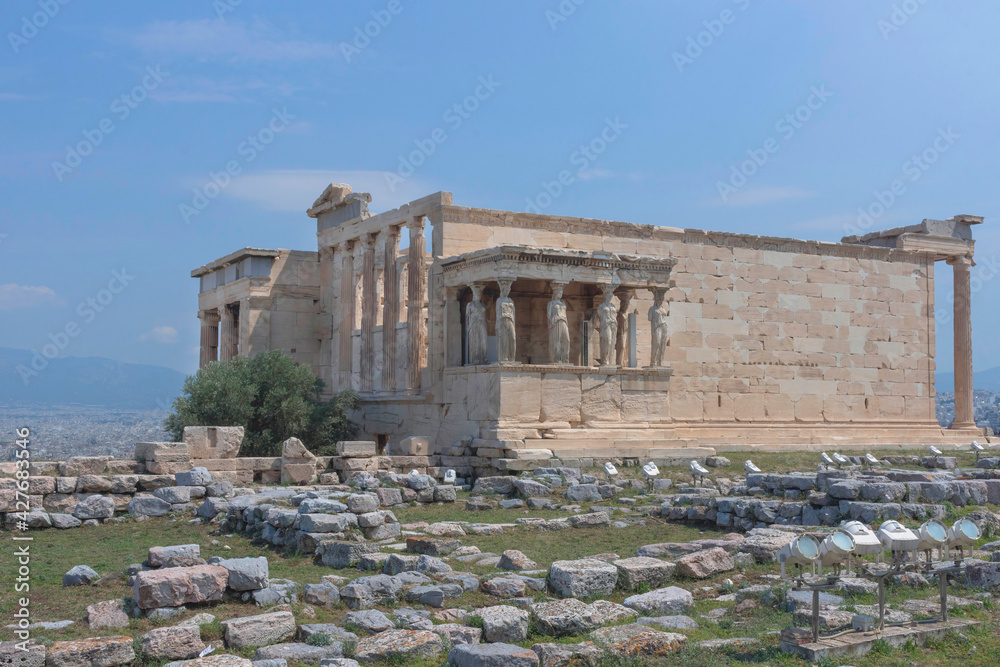 The ancient Erechtheion temple with beautiful Caryatids on Acropolis hill, famous tourist attraction in Athens, Greece, in sunny summer day
