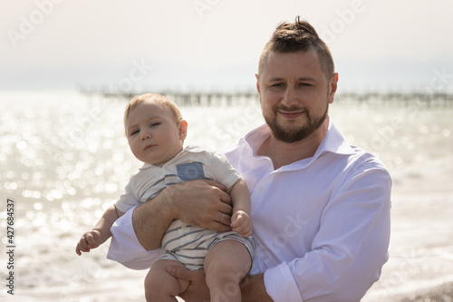 Happy father on vacation - man hugging his little baby son
