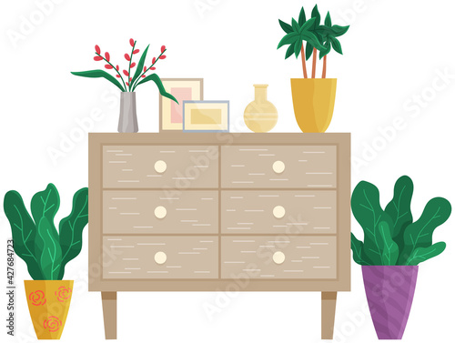 Wooden commode with drawers isolated on white. Photo frames, vase with bouquet, houseplants